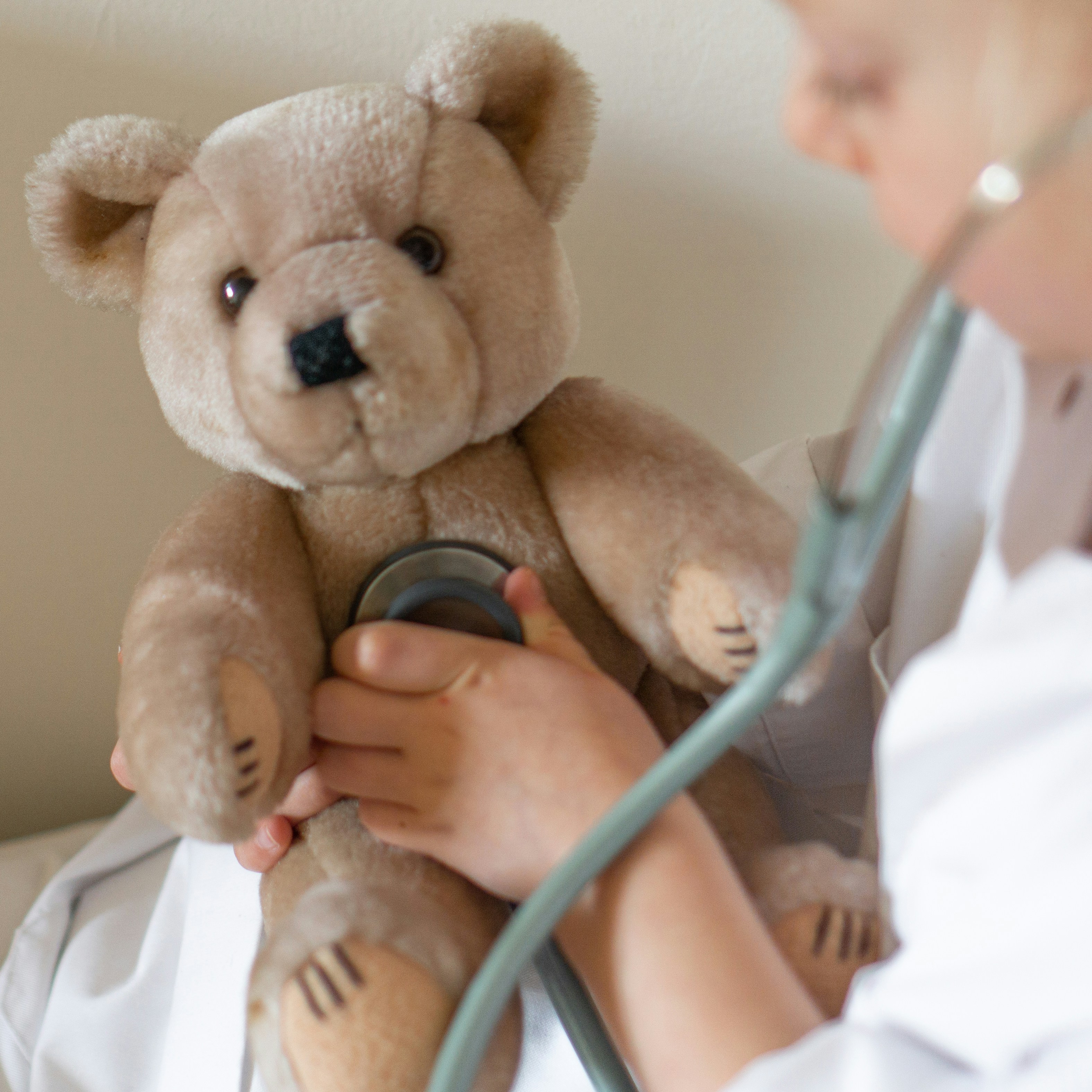 Geduldige Sprechstunde: Medizinerin mit Stethoskop und Teddybär